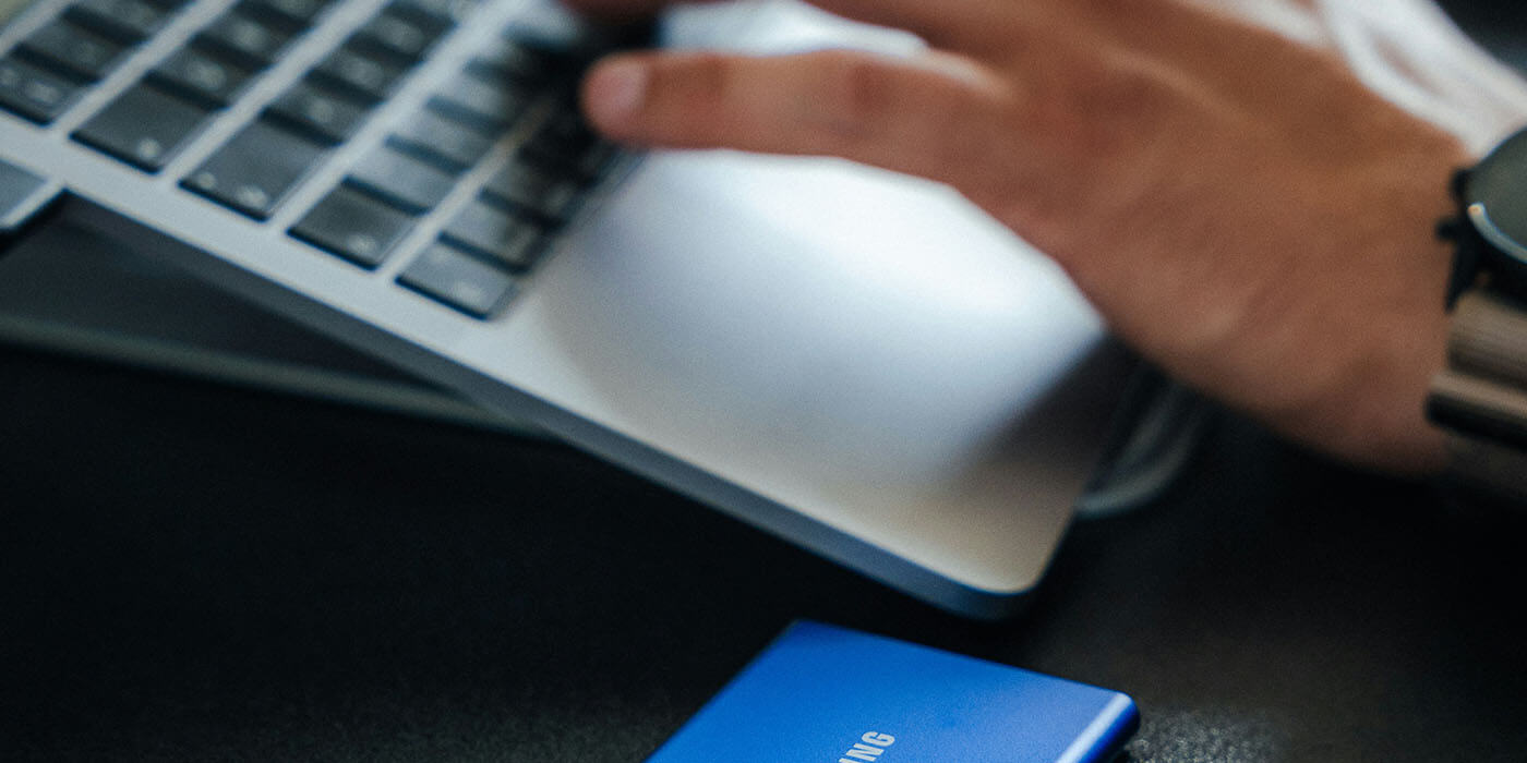 Ein Foto (Nahaufnahme) eines Notebooks mit einer externen Festplatte: Ein Symbol für digitale Geschäftsunterlagen, die GoBD-konform archiviert werden müssen